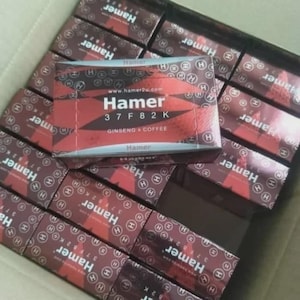 May include: A box filled with numerous small, rectangular boxes. Each box is primarily dark red with a lighter red design and the word "Hamer" in large white letters. The text "37 F 82 K" and "Ginseng & Coffee" are also visible.