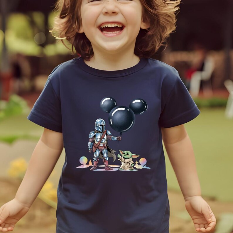 May include: Navy blue t-shirt featuring a cartoon illustration of The Mandalorian holding a black balloon with Mickey Mouse ears, and Grogu. The design includes colorful accents and is suitable for children.