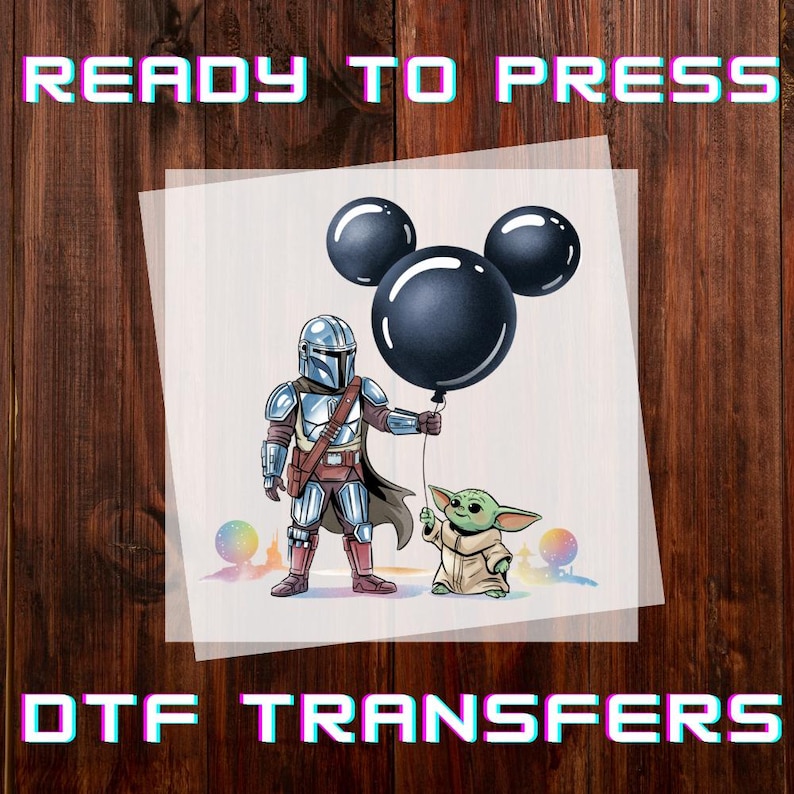 May include: DTF transfer featuring The Mandalorian and Grogu holding a Mickey Mouse-shaped balloon. The image includes the text "READY TO PRESS" and "DTF TRANSFERS" in a colorful, pixelated font. The background is a wooden surface.
