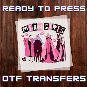 May include: DTF transfer featuring four cartoon villains from Disney films. The image includes the text "MEAN GIRLS" in a pink and black font, with the words "READY TO PRESS" and "DTF TRANSFERS" above and below the main image.