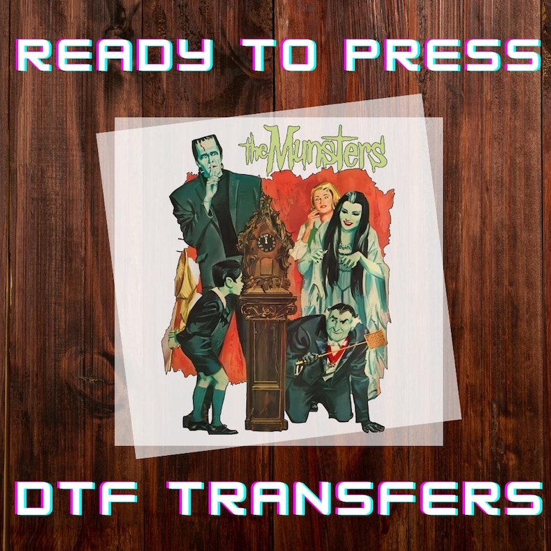 Peut inclure: Transfert DTF repr&eacute;sentant la famille Munster. L'image comprend Frankenstein, Lily Munster, Herman Munster et d'autres personnages. Les mots "READY TO PRESS" et "DTF TRANSFERS" sont affich&eacute;s dans une police r&eacute;tro.
