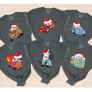 A collage of six t-shirts featuring cartoon cars and trucks with Santa hats on them.