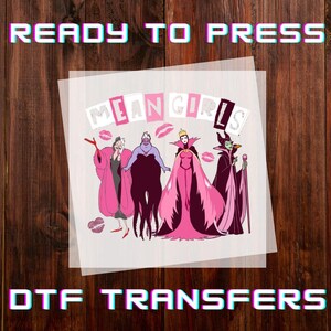 May include: DTF transfer with the text "READY TO PRESS" and "DTF TRANSFERS". The design features the words "MEAN GIRLS" and illustrations of Disney villains in pink and purple, with lipstick kiss marks.