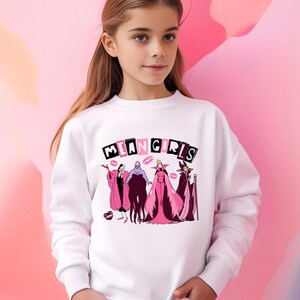 May include: White sweatshirt with the text "MEAN GIRLS" in black and pink, and cartoon villain characters and lipstick kiss graphics. The sweatshirt has a crew neck.