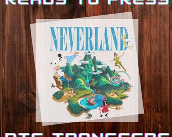 May include: A DTF transfer featuring a colorful illustration of Neverland with Peter Pan, Tinkerbell, and Captain Hook. The words "READY TO PRESS" and "DTF TRANSFERS" are displayed in a pixelated font above and below the image.
