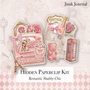 May include: A collection of pink and cream-colored paper ephemera, including a vintage television, roses, a teddy bear, and a telephone booth. The text "NOW PLAYING" and "VINTAGE" are visible. The kit is labeled "HIDDEN PAPERCLIP KIT" and "Romantic Shabby Chic."