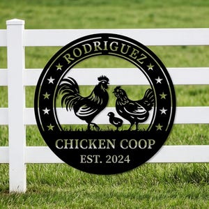 May include: Black metal sign with a rooster, hen, and chick silhouette, with the text "RODRIGUEZ" and "CHICKEN COOP EST. 2024" in a circular design. The sign is mounted on a white fence against a green grass background.