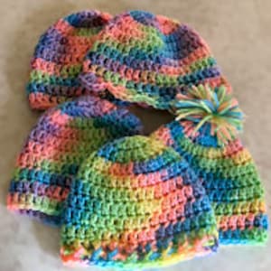 May include: Five rainbow crochet hats, one with a fluffy pom-pom.