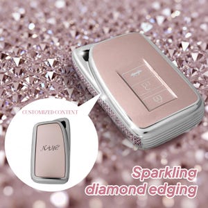 Puede incluir: Una funda para llave de coche en oro rosa con bordes de diamantes brillantes. La funda tiene un marco plateado y presenta tres botones. La imagen también muestra una funda para llave más pequeña con la palabra "NAME". El texto "CUSTOMIZED CONTENT" también es visible.