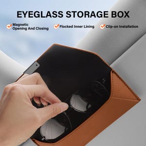 May include: A tan leather-look eyeglass storage box with a black interior. The text EYEGLASS STORAGE BOX is visible, along with features: Magnetic Opening And Closing, Flocked Inner Lining, and Clip-on Installation. The case holds black glasses.