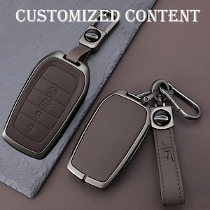 May include: Two brown leather car key fobs with silver-tone metal accents. One fob has buttons and a key ring, the other has a key ring and a leather strap with the initials "MFT". The text "CUSTOMIZED CONTENT" is at the top.