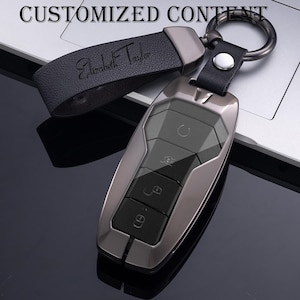 以下が含まれることがあります： 白いセラミックマグカップ、黒いハンドル、手書き風の「But First, Coffee」の文字。 マグカップは白い表面に置かれています。 マグカップの高さは約10cmです。