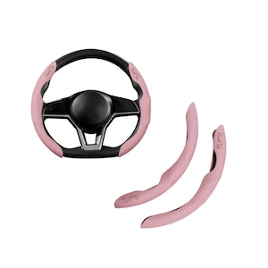 Könnte beinhalten: Ein Lenkrad für ein Auto mit schwarzer Mitte und Felge, akzentuiert mit hellrosa Abschnitten. Zwei passende hellrosa Griffbezüge sind ebenfalls enthalten. Das Wort "Elite" ist auf den rosa Abschnitten aufgedruckt.