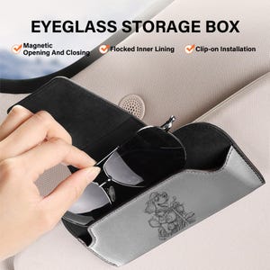 May include: A grey eyeglass storage box with a magnetic opening and closing mechanism, a flocked inner lining, and a clip-on installation feature. The exterior features a graphic of a dog riding a motorcycle. Text reads: EYEGLASS STORAGE BOX.