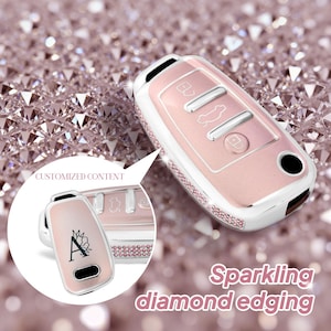 May include: A pink and white car key fob cover with sparkling diamond edging. The cover has a pink center with silver buttons and a white border. The text "CUSTOMIZED CONTENT" is visible.