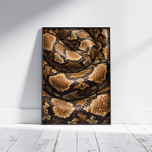 May include: A framed print featuring a close-up of a coiled snake. The snake's skin displays a pattern of brown, tan, and black scales. The artwork is displayed against a white wall and a wooden floor.