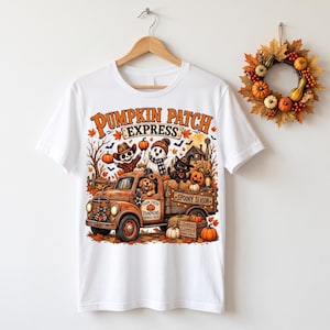 May include: A white t-shirt featuring a graphic of a rusty orange truck labeled Pumpkin Patch Express. The design includes a skeleton, a ghost, a black cat, and a dog, surrounded by pumpkins, autumn leaves, and a sign reading Spooky Season.