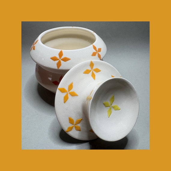 A vivid atomic-orange lidded studio pottery jar — bold enough to anchor a bathroom counter or shelf and functional enough to actually use, 17 favorites backs up the wow factor.