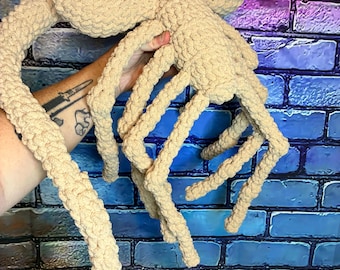 Gehaakte amigurumi knuffel in de vorm van een buitenaards gezicht (Fysiek product)