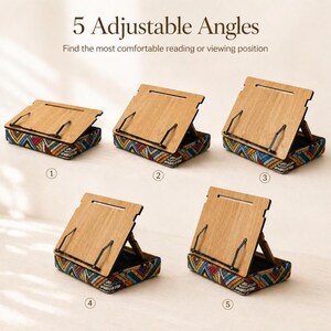 Puede incluir: Atril de madera con 5 &aacute;ngulos ajustables. El soporte tiene una superficie de madera marr&oacute;n claro y una base con un colorido estampado geom&eacute;trico. El texto "5 Adjustable Angles" y "Find the most comfortable reading or viewing position" son visibles.