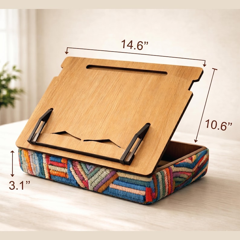 Puede incluir: Atril de madera con base bordada colorida. El atril mide 37 cm de ancho, 27 cm de alto y 8 cm de profundidad. El atril tiene un acabado de madera natural y soportes de metal negro.
