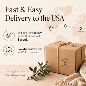 May include: A brown cardboard gift box tied with twine, featuring a circular stamp that reads Handmade With Care. Beside the box lies a small green olive branch. The background displays text about delivery to the USA and a world map graphic.