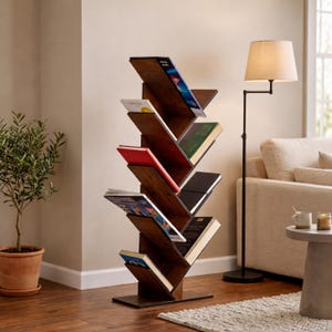 Puede incluir: Una estantería de madera de color marrón oscuro con una estructura vertical en forma de árbol que cuenta con múltiples estantes inclinados. La unidad contiene varios libros con portadas coloridas, incluyendo lomos azules, rojos y verdes, dispuestos a lo largo de la columna central.