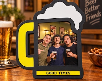 Puede incluir: Un marco de fotos negro y amarillo con forma de jarra de cerveza y un diseño de espuma blanca en la parte superior. El marco presenta el texto "GOOD TIMES" en letras negras sobre una barra horizontal amarilla en la base y contiene una foto.