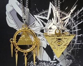 Puede incluir: Dos collares con colgantes dorados. Uno es un triángulo dentro de un círculo con puntas colgantes, el otro es un triángulo dorado. Ambos cuelgan de cadenas plateadas. El fondo es negro con diseños gráficos blancos y texto japonés.