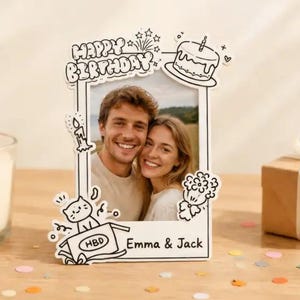 May include: A white photo frame with a black outline, featuring the words "Happy Birthday" and a picture of a smiling couple. The frame has decorative elements like a cake, candle, and a cat in a box. The names "Emma & Jack" are also visible.