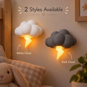 Pode incluir: Duas luminárias de parede em formato de nuvem, uma branca e uma cinza-escura, cada uma com um raio amarelo brilhante apontado para baixo. O texto 2 Styles Available está centralizado acima, com as etiquetas White Cloud e Dark Cloud.