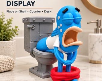 Puede incluir: Una figura impresa en 3D de un pez azul con la boca abierta sentado en un inodoro gris. El pez lleva una camiseta blanca y un salvavidas rojo alrededor de la cintura. El texto superior dice FREESTANDING DISPLAY Place on Shelf Counter Desk.
