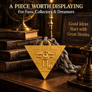 Może przedstawiać: Złoty trójkątny wisiorek z wygrawerowanym symbolem oka, przymocowany do grubego szarego łańcucha. Tekst A PIECE WORTH DISPLAYING For Fans, Collectors & Dreamers oraz Good Ideas Start with Great Stories jest widoczny w tle.