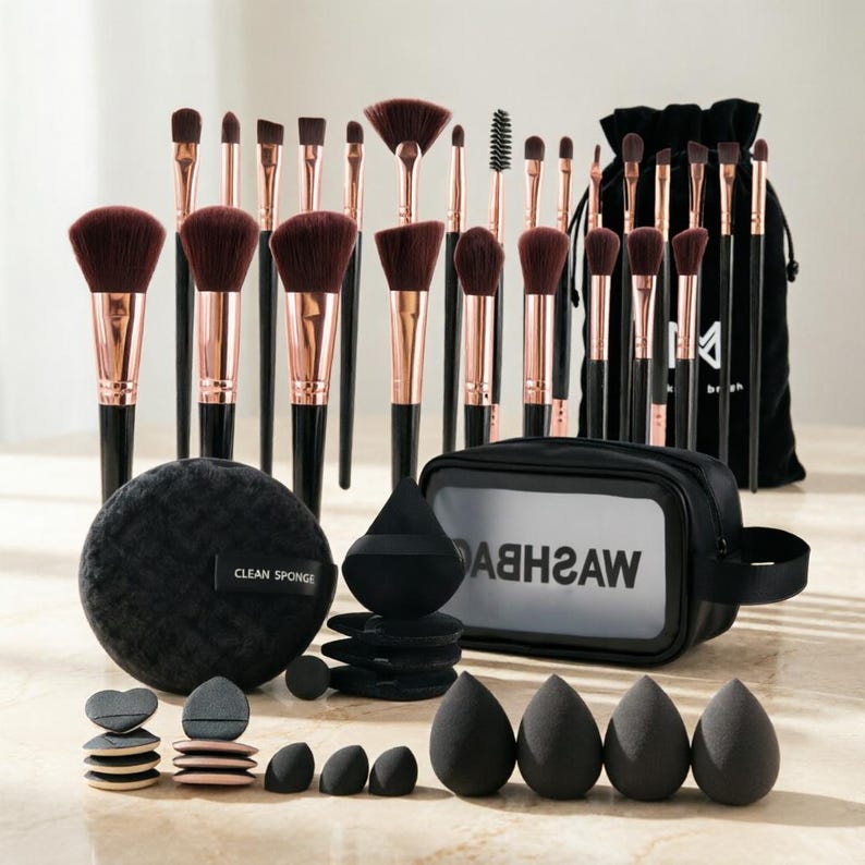 May include: A complete makeup brush set with black handles, rose gold ferrules, and dark brown bristles. The set includes various brush sizes, a black bag, sponges, and a black cosmetic bag with the text "WASHBAG".