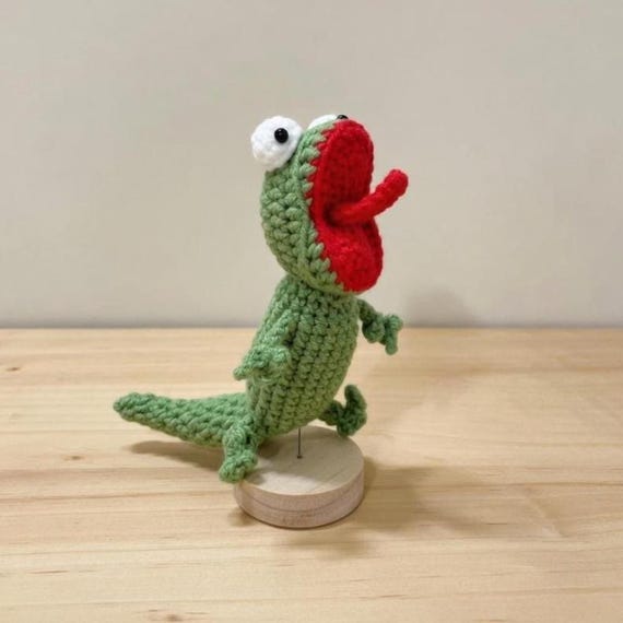 A handmade amigurumi lizard mid-scream — the 'screaming' expression is a genuinely funny sculptural detail that makes it immediately shareable.