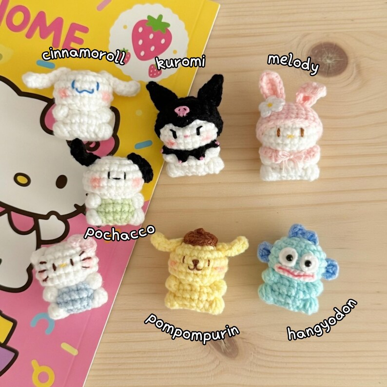 May include: A collection of seven crocheted character figures, including Cinnamoroll, Kuromi, Melody, Pochacco, Pompompurin, and Hangyodon. Each figure is crafted with detailed features and vibrant colors, set against a colorful background.