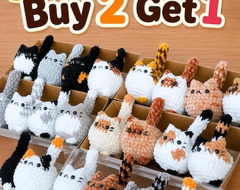 May include: A collection of handmade crochet cat toys in various colors, including white, gray, black, and orange, arranged in cardboard boxes. The image includes the text "Buy 2 Get 1". These cat toys are a charming addition to any cat lover's collection.