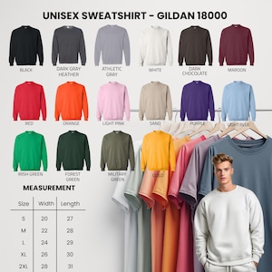 May include: A display of Gildan 18000 unisex sweatshirts in various colors, including black, gray, white, red, orange, and green. The image also shows a size chart with measurements in inches for width and length.