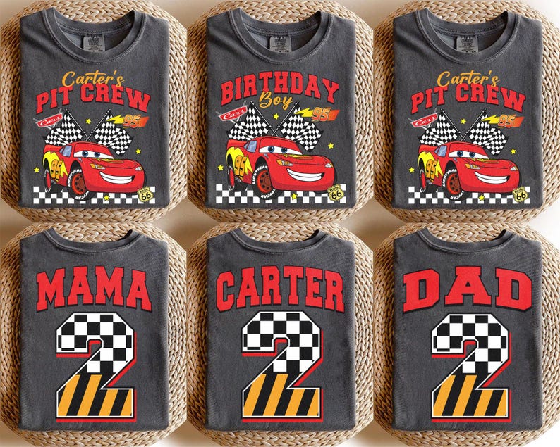 May include: Six gray t-shirts with racing-themed designs. The shirts feature text like "Carter's Pit Crew", "Birthday Boy", "Mama", "Carter", and "Dad". Each shirt has a red race car graphic or a number 2 with a checkered flag design.