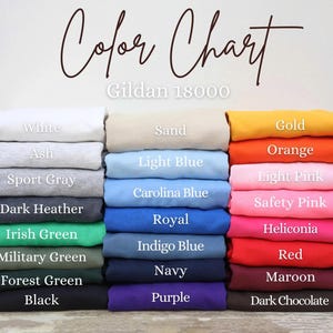 Puede incluir: Una carta de colores muestra una variedad de colores de tela, incluyendo blanco, negro y tonos de azul, verde y rosa. El texto "Color Chart" est&aacute; escrito en cursiva en la parte superior, con "Gildan 18000" debajo.