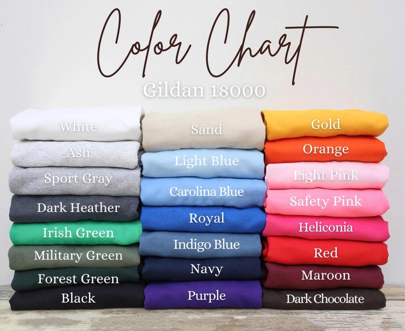 Puede incluir: Una carta de colores muestra una variedad de colores de tela, incluyendo blanco, negro y tonos de azul, verde y rosa. El texto "Color Chart" est&aacute; escrito en cursiva en la parte superior, con "Gildan 18000" debajo.