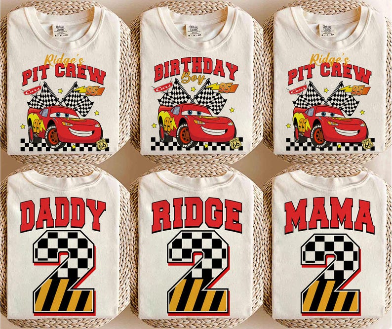 May include: Cream-colored t-shirts with various designs. Some shirts feature a red race car with the text "Ridge's Pit Crew" and "Birthday Boy". Other shirts display "Daddy", "Ridge", and "Mama" with a number 2 in a checkered and striped design.