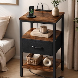 May include: A brown and black nightstand with a charging station, drawer, and shelves. The nightstand has a rustic wood grain finish and a black metal frame. A phone is charging on top. A small vase and a woven basket are on the shelves.