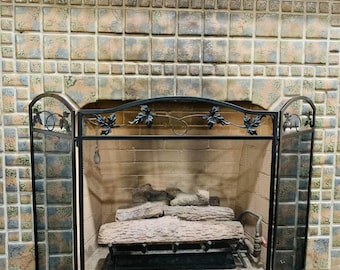 Pantalla para chimenea de 3 paneles, de acero negro con diseño de hojas y malla decorativa.