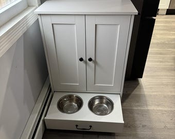 Comedero de madera para perros con armario de almacenamiento y cuencos elevados.