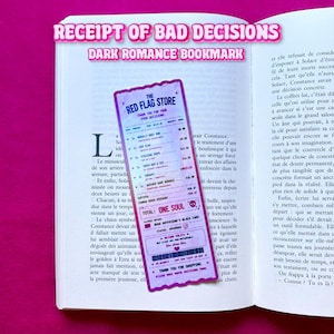 Pode incluir: Um marcador de página retangular roxo projetado como um recibo de loja intitulado The Red Flag Store. Lista itens como Red Flag e Stalking Trope com preços, um total de One Soul e um código de barras, colocado sobre uma página de livro.