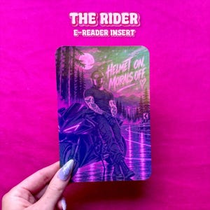Könnte beinhalten: Ein rechteckiger E-Reader-Einsatz mit einer grafischen Illustration einer Person mit Helm, die auf einem Motorrad sitzt. Die Szene spielt bei Nacht mit Vollmond, Wald und Straße. Der Text lautet "HELMET ON, MORALS OFF" mit einem Herzsymbol.