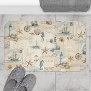 May include: Rectangular bath mat with a nautical theme. The mat features a collage of vintage illustrations including sailboats, lighthouses, seashells, and seahorses in shades of blue, beige, and brown. Gray slippers are in the foreground.