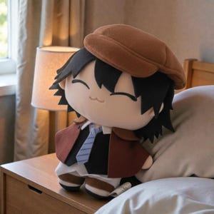 May include: A plush doll of a character with black hair, wearing a brown hat, a brown coat, a black shirt, and a blue tie. The doll is sitting on a wooden nightstand next to a lamp with a beige lampshade. The background includes a bed and a window.