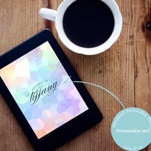 May include: An e-reader shows a colourful geometric design with the text "Property of Tiffany." A white coffee cup sits nearby on a wooden surface. A circular graphic says "Personalize me!"